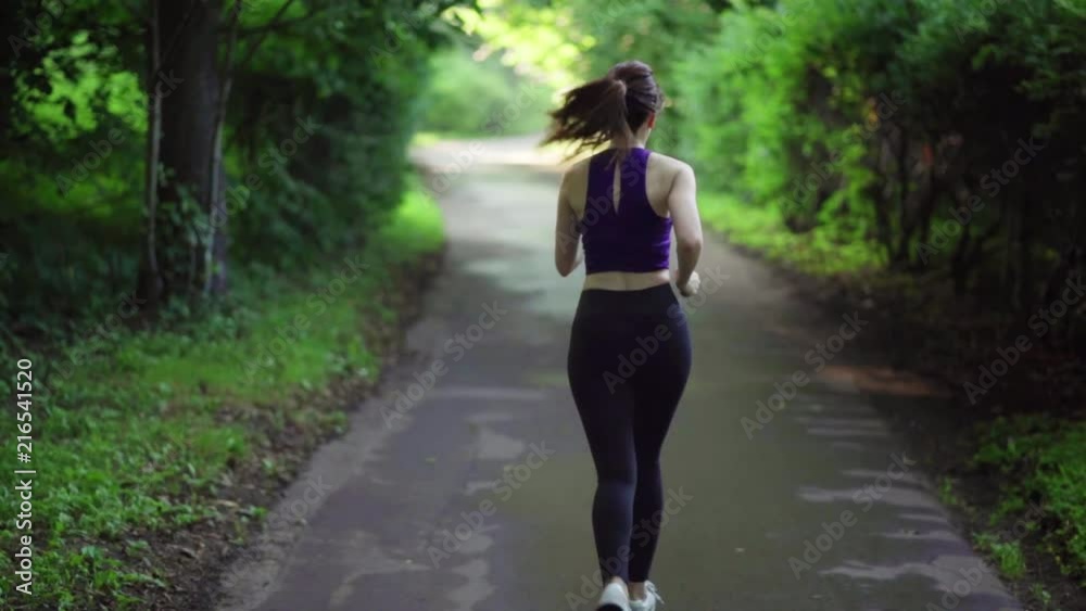Girl runs through park in the morning Girl runs through park in the morning