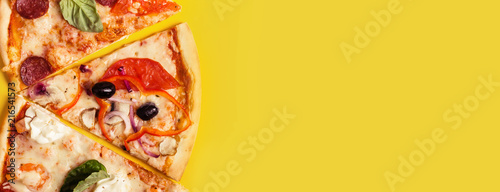 selection of Assorted pieces pizza on yellow background. Pepperoni, Vegetarian and Seafood Pizza