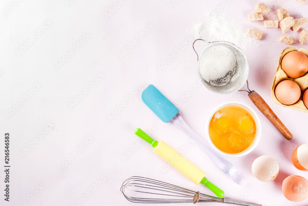 Ingredients and utensils for cooking baking egg, flour, sugar, whisk, rolling pin, on light pink background, top view copy space Ingredients and utensils for cooking baking egg, flour, sugar, whisk, rolling pin, on light pink background, top view copy space