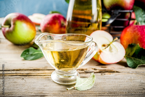 Homemade apple cider vinegar with fresh apples om wooden rustic background copy space