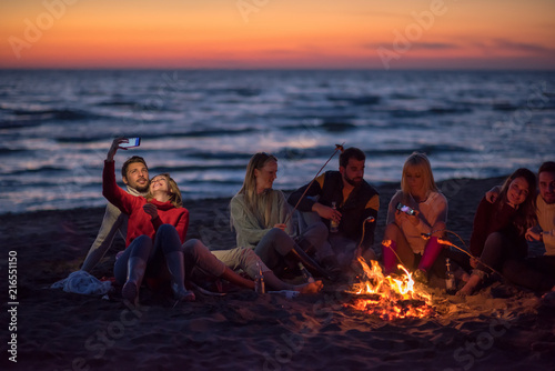 Fototapeta Naklejka Na Ścianę i Meble -  a group of friends enjoying bonfire on beach