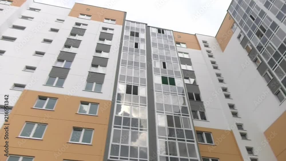 New multi-apartment panel house with glazed loggias and balconies. Frame-panel buildings. The panels are painted in ocher color, gray and white. New multi-apartment panel house with glazed loggias and balconies. Frame-panel buildings. The panels are painted in ocher color, gray and white.