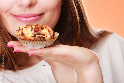 Closeup woman holds cake in hand