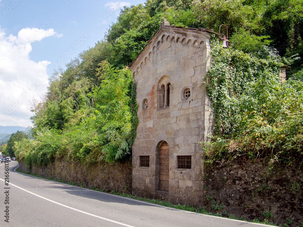 Ancient small Catholic church, closed, neglected and overgrown. Lunigiana, Italy.