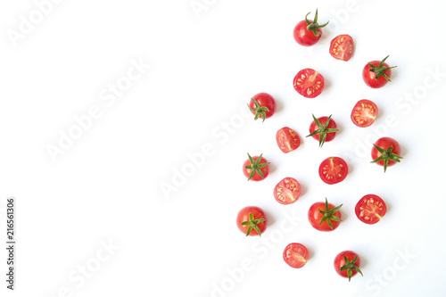 Bunch of beautiful juicy organic red cherry tomatoes whole & halved on white background. Top view of shiny polished vegetables. Clean eating concept. Vegetarian vegan detox diet. Copy space, flat lay.