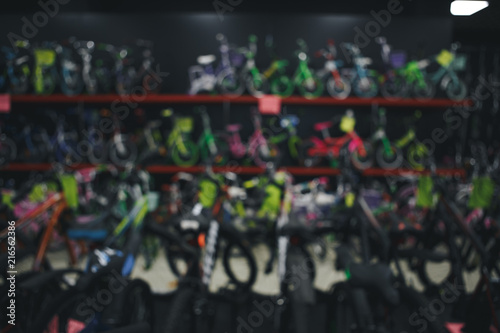 Blurred image multiple rows of kid bikes hanging on rack at department store in Humble, Texas, US. Various bright color bicycles for kid in bike shop. Active lifestyle concept background, vintage tone