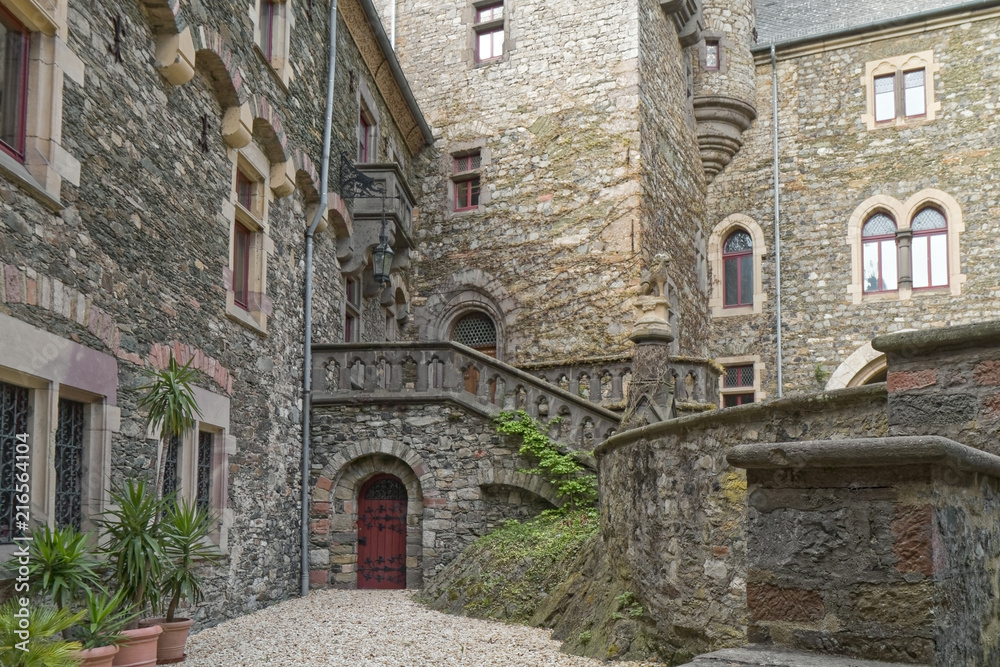Old, stone castle courtyard with wooden door in the background
