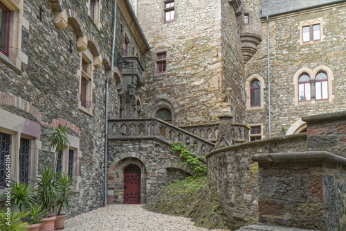 Fototapeta Naklejka Na Ścianę i Meble -  Old, stone castle courtyard with wooden door in the background