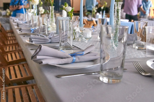 The chic restaurant is ready to receive guests. Blurred people in the background. Everything is ready for the wedding, celebrating the birthday, christening, another celebration.