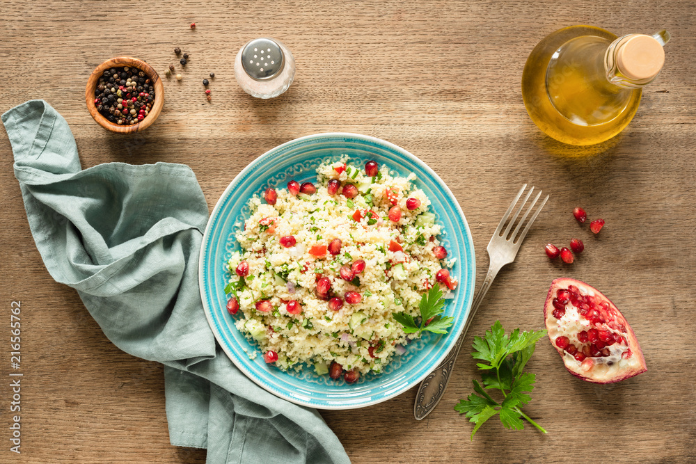 Vegetarian arabic couscous salad Tabbouleh with pomegranate seeds, parsley and olive oil. Top view