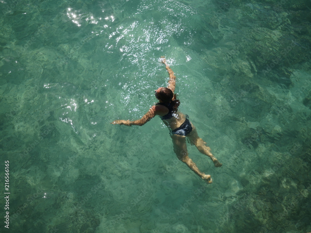 Woman swimming in a clear ocean water