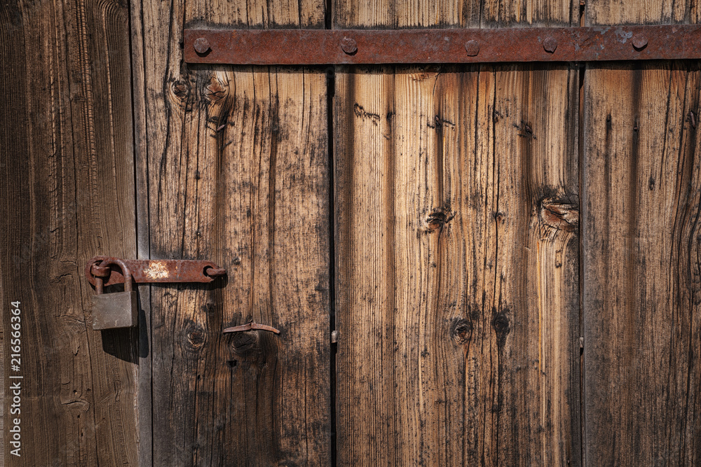 old abandoned locked door with rusty padlock.