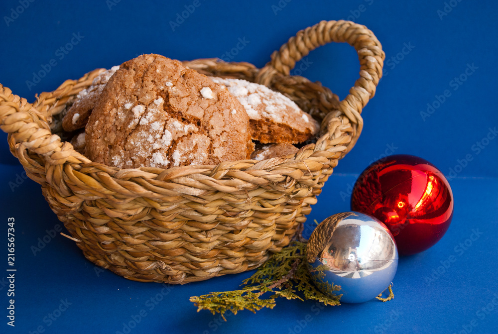 Basket with homemade cookies and christmas balls on blue background. Xmas greeting card.Food Holiday.