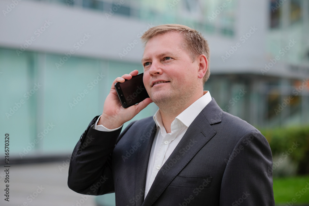 Middle aged confident businessman, talking on the phone, outside Middle aged confident businessman, talking on the phone, outside
