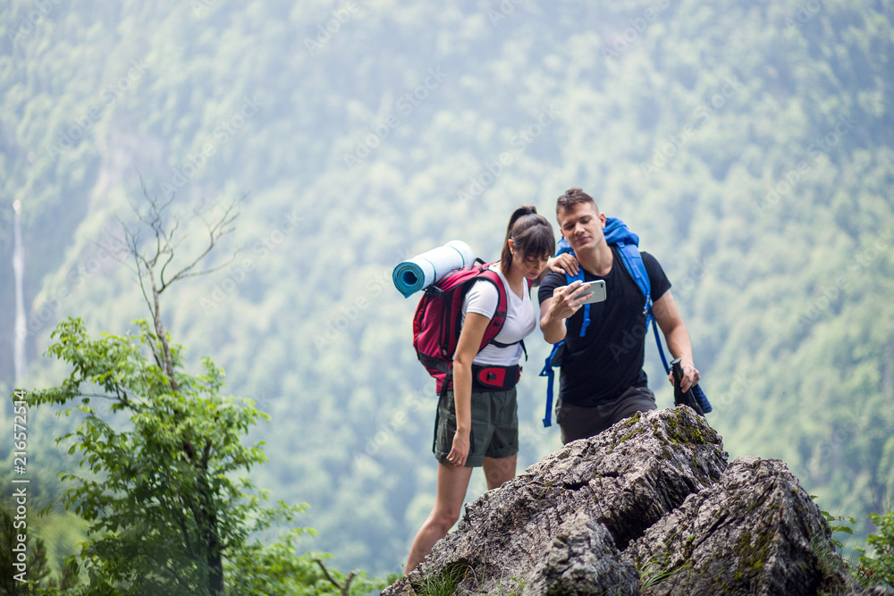 Hikers using smartphone while hiking