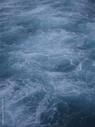 white foam rough water on blue water background