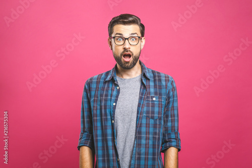 Canvastavla Indoor shot of amazed excited man doesn`t believe his success, keeps hands on head, stares at camera, says omg or wow