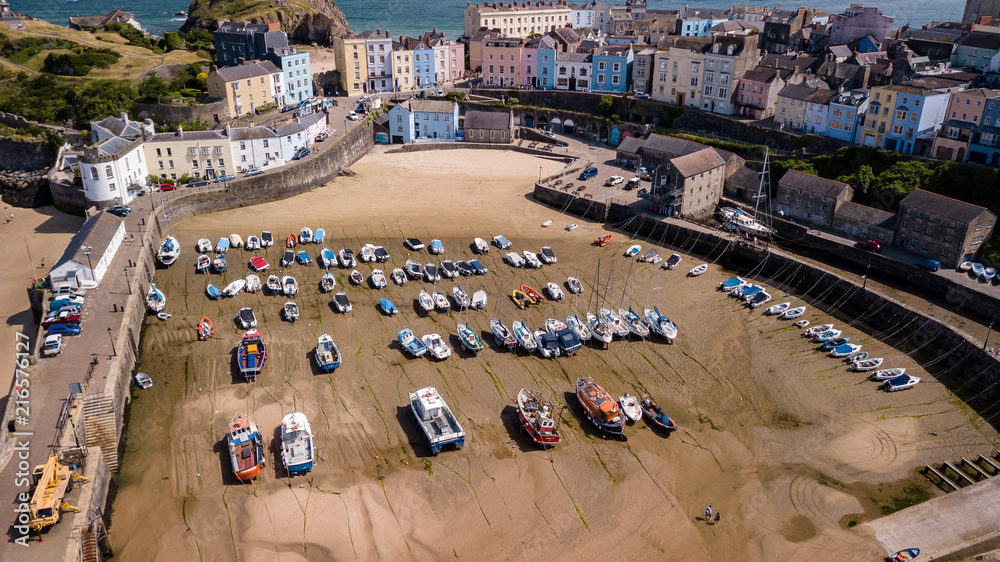 Aerial drone view of fishing boats beached at low tide in a harbour at the beautiful Welsh holiday resort of Tenby