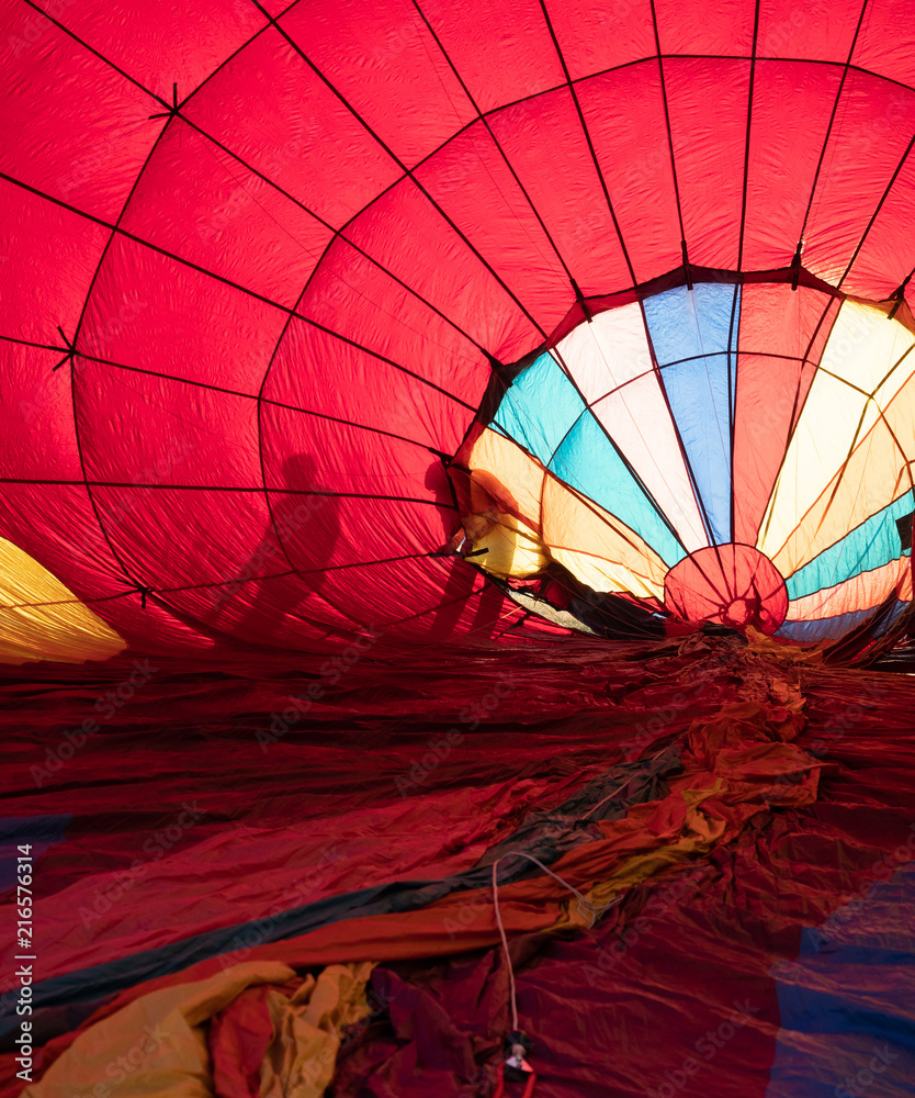 Fototapeta premium Two People Checking a Hot Air Balloon while it's being inflated.