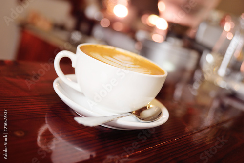 a cup of coffee with a pattern on a foam or latte-art close-up on a coffee house background