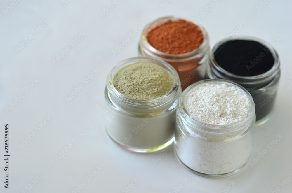 Top view of kaolin powder, activated charcoal, red, green and green cosmetic clays in jars. Deep cleansing bentonite (montmorillonite) clay for beauty spa face mask, body detox and hair treatments. Top view of kaolin powder, activated charcoal, red, green and green cosmetic clays in jars. Deep cleansing bentonite (montmorillonite) clay for beauty spa face mask, body detox and hair treatments.