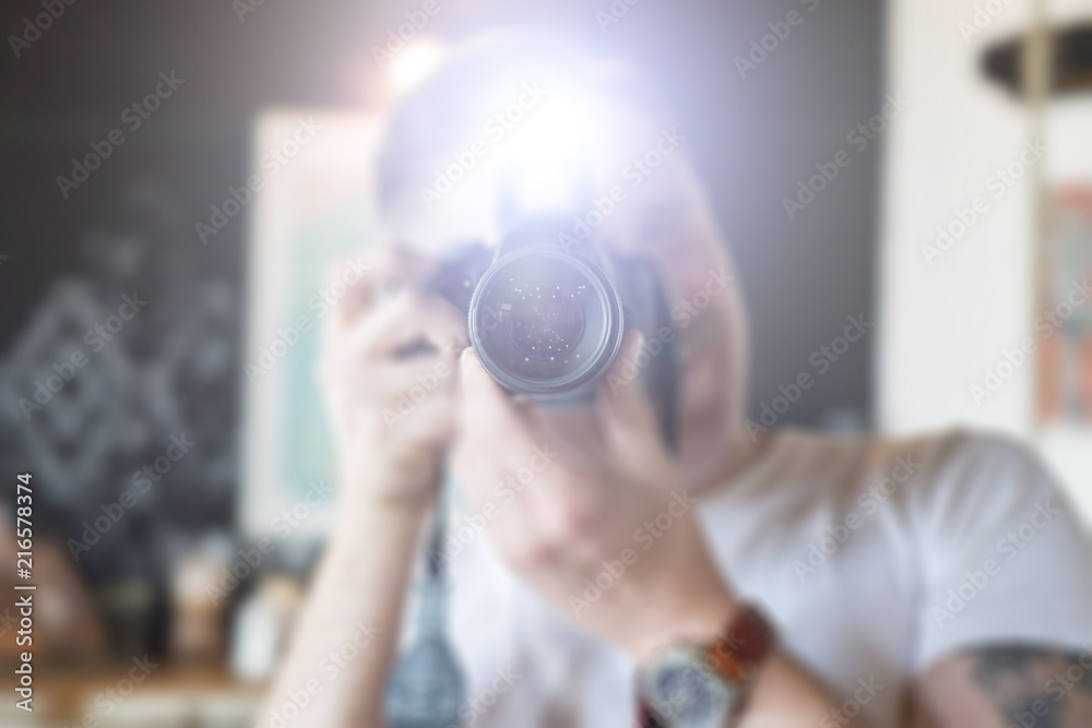 A man takes pictures on a camera with a flash - obrazy, fototapety, plakaty 