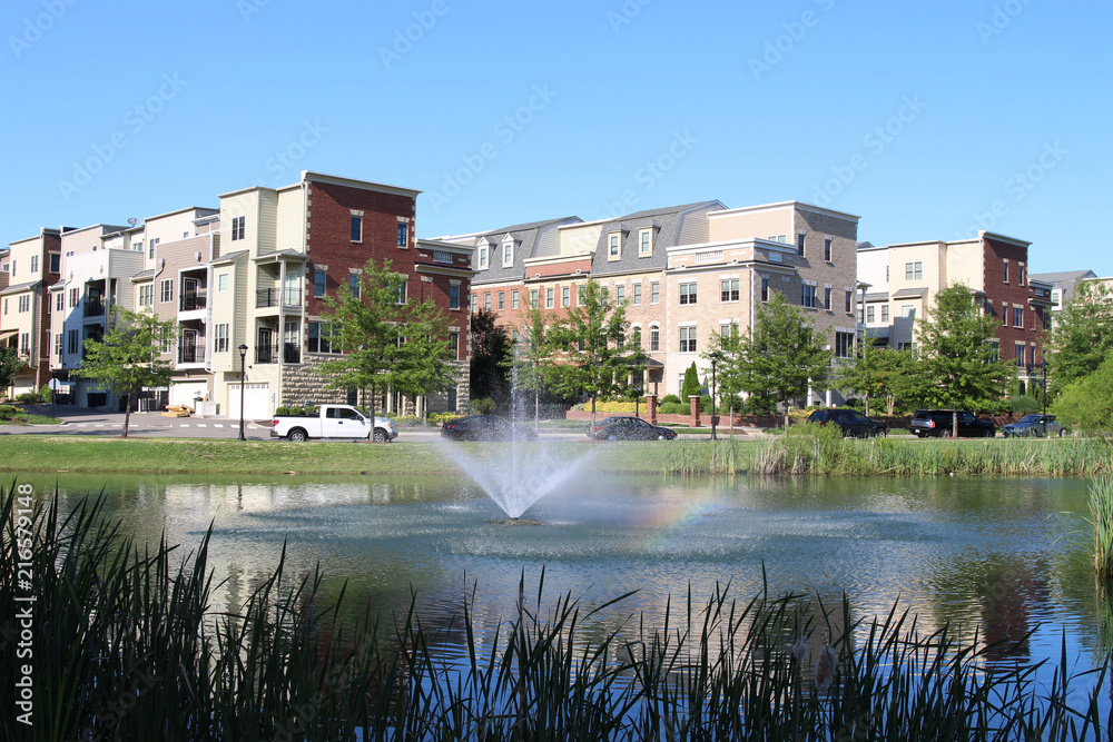 A pond with a fountain at modern townhouses in the summer. Richmond suburbs, Virginia