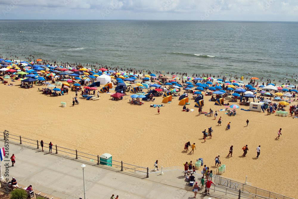 A view of a crowded beach and boardwalk. Virginia Beach on Independence Day, Fourth of July 2018, USA