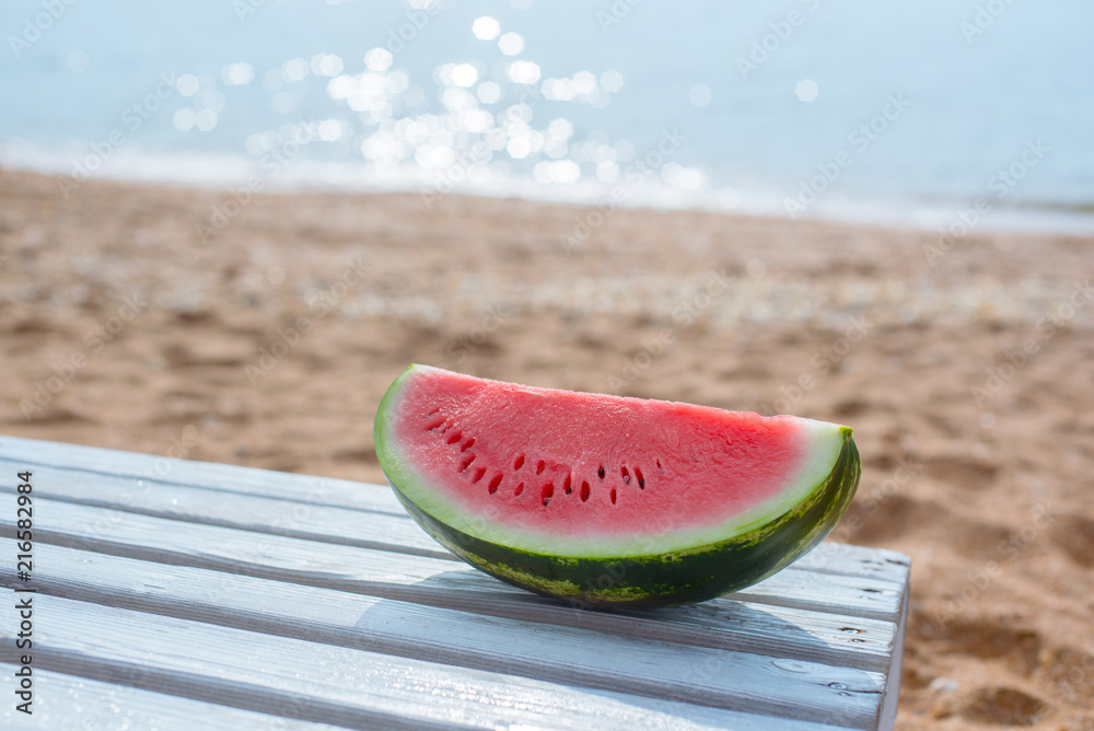 Watermelon on a background of a sandy beach and the sea. Watermelon on a background of a sandy beach and the sea.