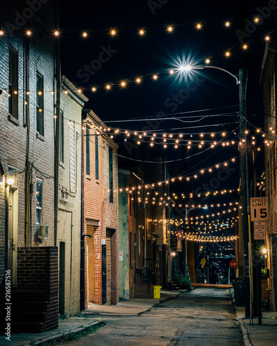 Fotografia String lights over Chapel Street at night in Butchers Hill, Baltimore, Maryland