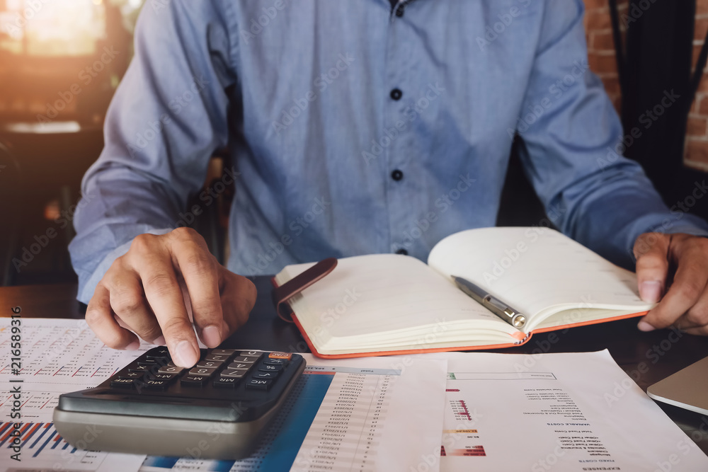 Bookkeeper accounting Concepts, Male use calculator, notebook, pen and computer laptop to monitor money saving reports budget to plan before retire. inspector accountant concept. Bookkeeper accounting Concepts, Male use calculator, notebook, pen and computer laptop to monitor money saving reports budget to plan before retire. inspector accountant concept.