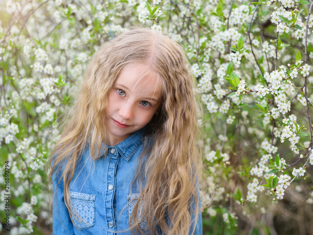 Portrait of a girl in a denim shirt with an interesting look in a cherry orchard. Portrait of a girl in a denim shirt with an interesting look in a cherry orchard.