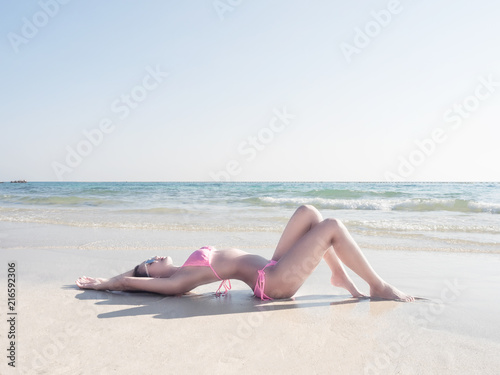 Maldive islands.Young fashion woman is relaxing sunbathing on the beach.Summer vacation holiday.Happy island lifestyle.Summer concept.