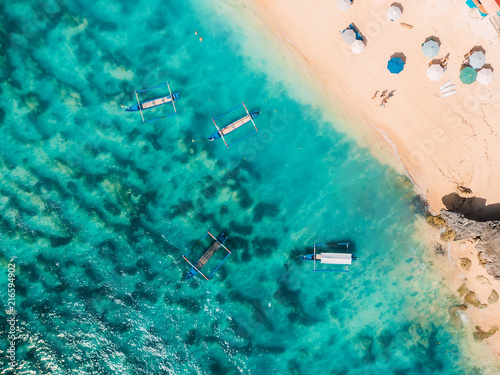Aerial view of sandy beach with turquoise sea water and local boats, drone shot © artifirsov