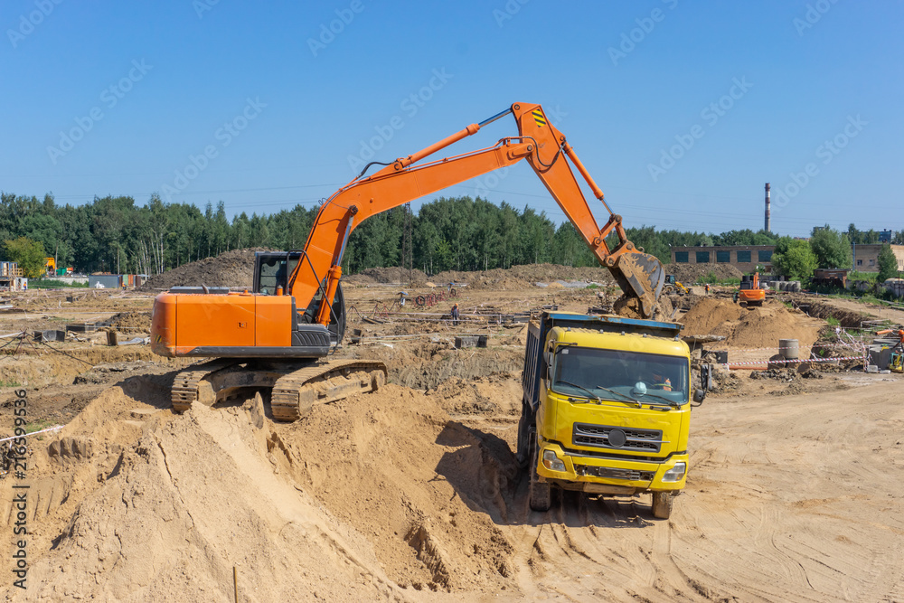 Excavator at the construction site will load the truck with sand Excavator at the construction site will load the truck with sand
