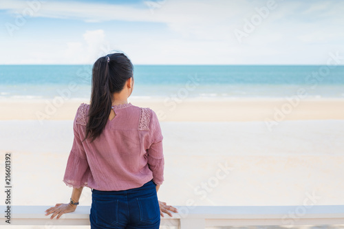 Traveler Asian woman feeling happy on the beach to the summer sea background.Concept of relax on vacation holidays. © bunditinay