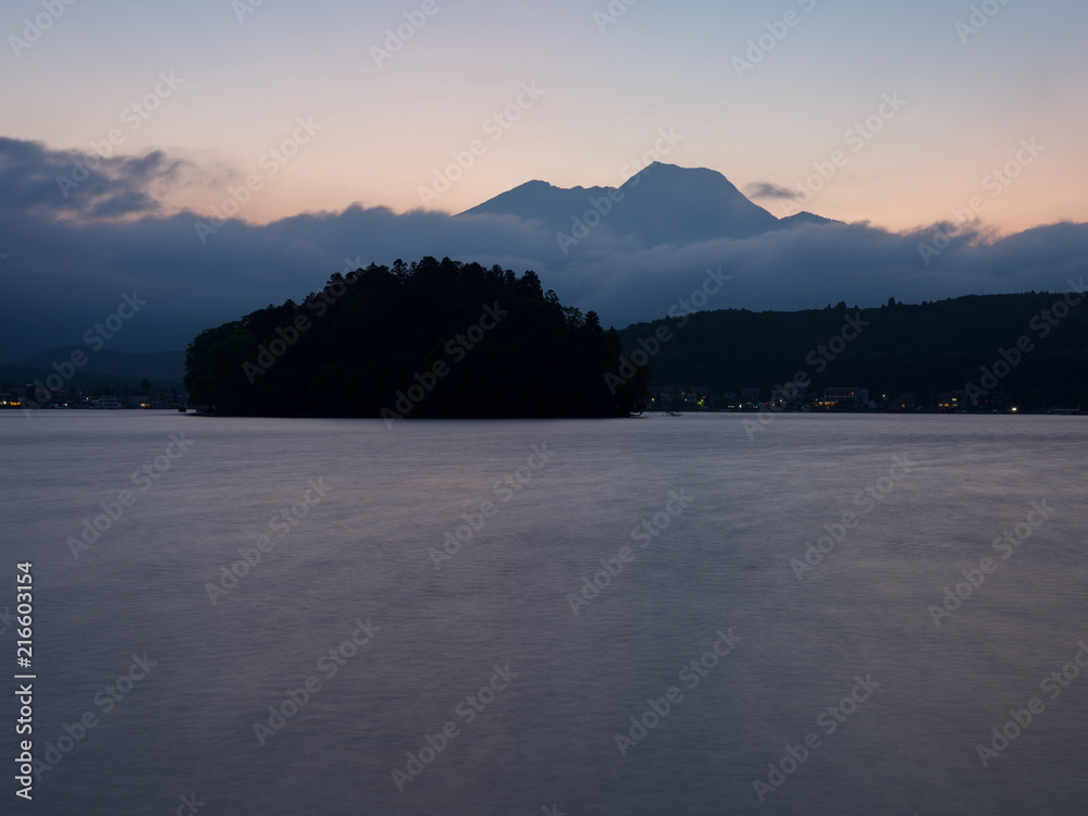 夕焼けの湖畔にて、山には雲が棚引いて、島と湖面が夕焼け色にそまる。。