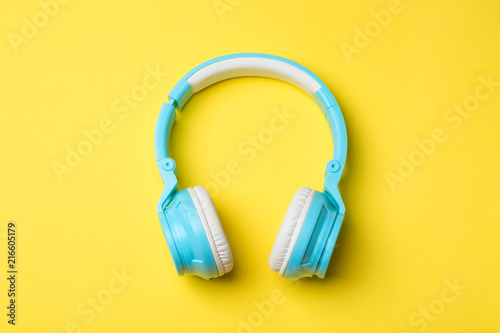 Blue modern wireless headphones on yellow background