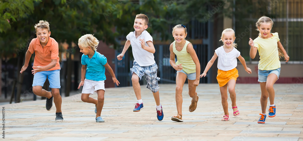 Obraz premium Group of happy children running together in town on summer