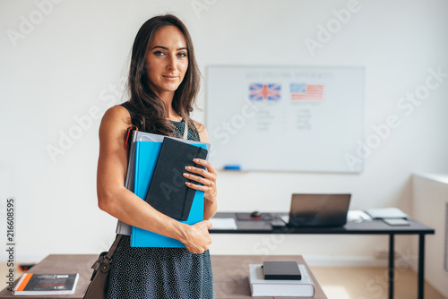 Obraz na plátně Female student with books smiling and looking at camera