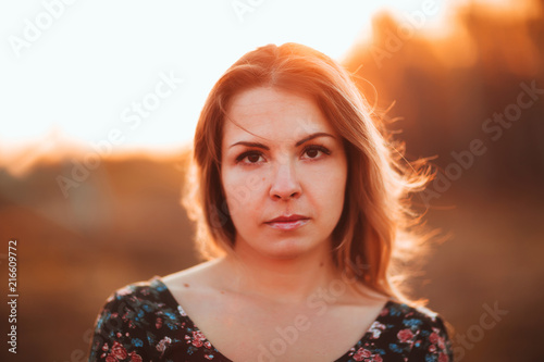 portrait of a beautiful girl in a field on a sunset background