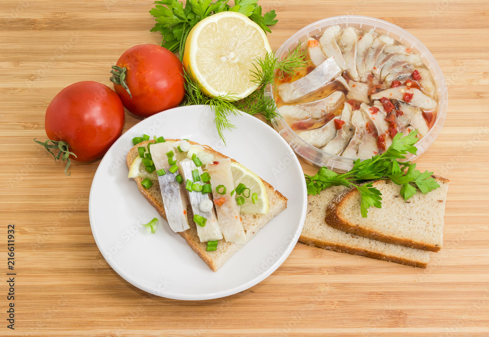 Open sandwich with pickled herring and ingredients for its preparation Open sandwich with pickled herring and ingredients for its preparation