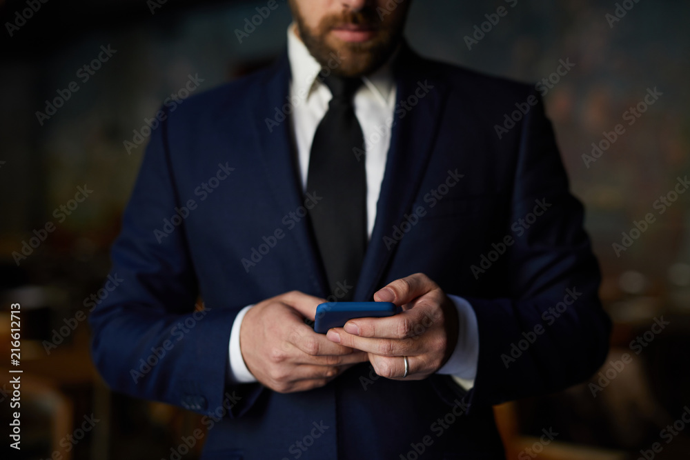 Close-up of bearded businessman in formal jacket using smartphone for work: he checking message or surfing the net Close-up of bearded businessman in formal jacket using smartphone for work: he checking message or surfing the net