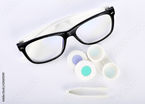 Contact lens, contact lens case, tweezers on white background. Correction of vision.