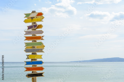 Multiple blank signs on a wooden pole in the beach.place for text.