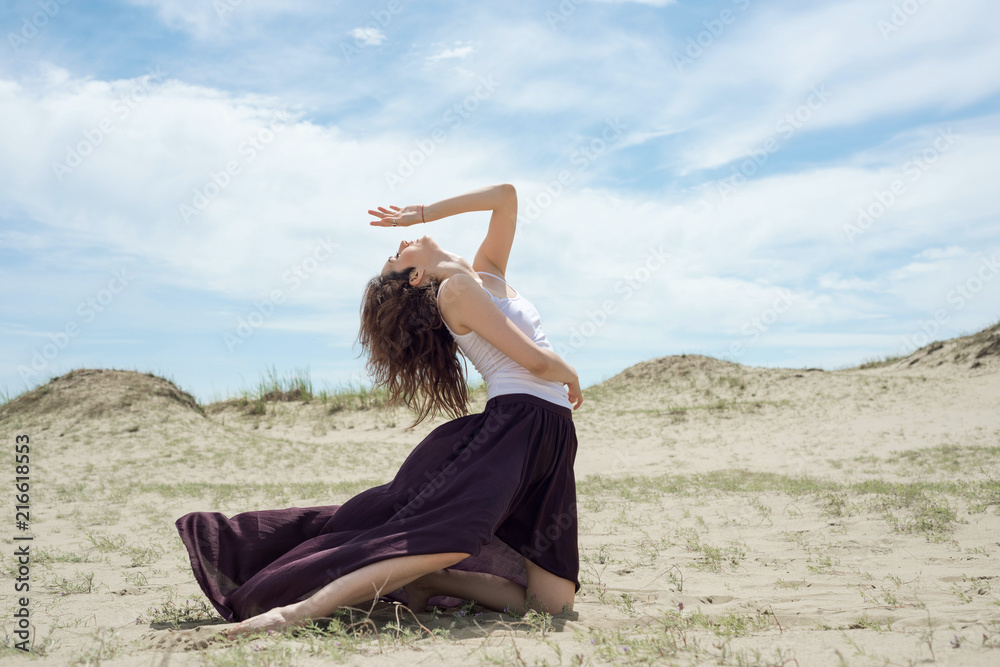 Young woman dances and extends her hands to the sky Young woman dances and extends her hands to the sky