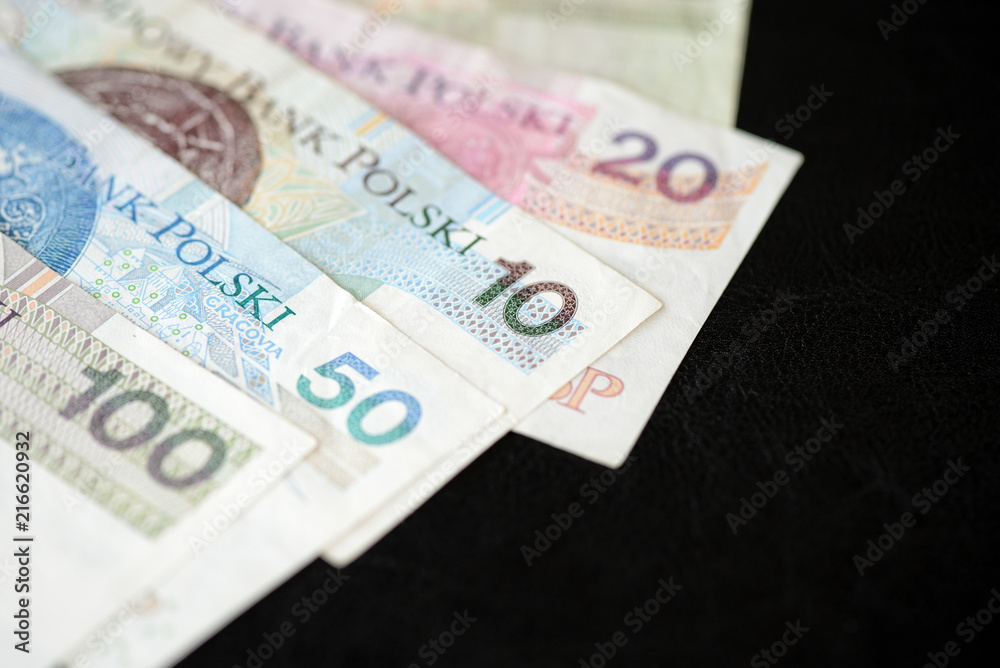 Several banknotes of Polish zloty on a dark background close up Several banknotes of Polish zloty on a dark background close up