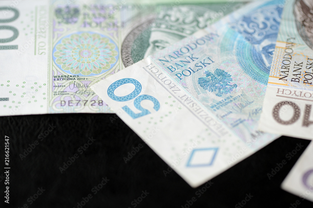 Fototapeta premium Several banknotes of Polish zloty on a dark background close up