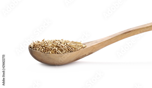 Oats in wooden spoon isolated on white background