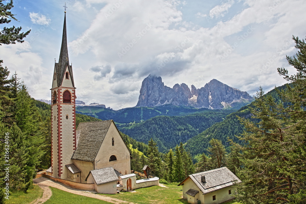 Saint Giacomo church near Santa Cristina and Ortisei with Sassolungo and Sassopiatto mountains in the background, Val Gardena, Dolomites, Italy